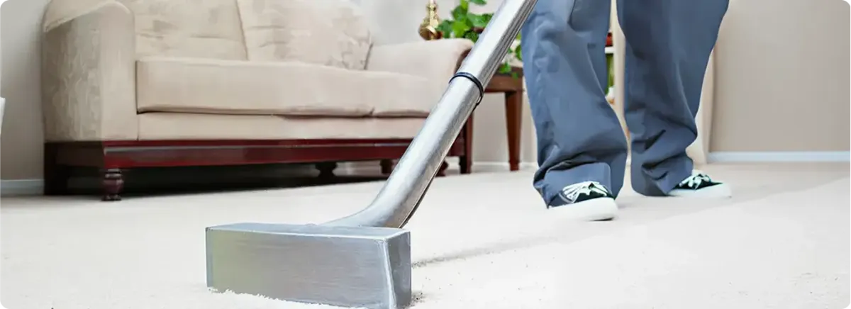 Carpet cleaning technician using a hot-water extraction wand on a light-colored carpet in a living room, South Bend, IN.